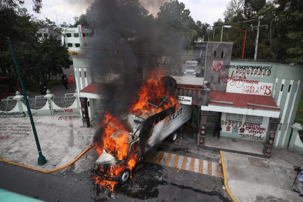 Normalistas de Ayotzinapa derriban puerta de Campo Militar 1 y queman camión